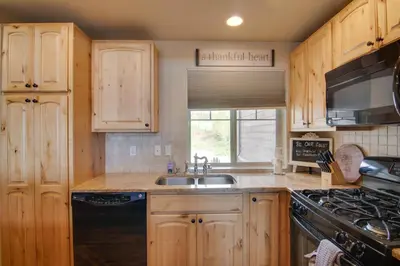 a kitchen with wooden cabinets and a sink and a stove at Winter Park Chalet with Hot Tub and Free Shuttle! in Fraser