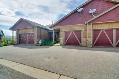 a house with two garage doors on a driveway at Winter Park Chalet with Hot Tub and Free Shuttle! in Fraser