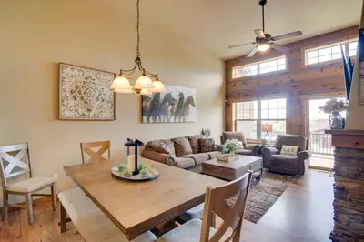 a dining room and living room with a wooden table at Winter Park Chalet with Hot Tub and Free Shuttle! in Fraser