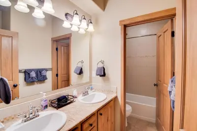 a bathroom with two sinks and a mirror at Winter Park Chalet with Hot Tub and Free Shuttle! in Fraser
