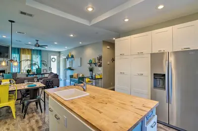 a kitchen with white cabinets and a kitchen island with a sink at 7 Mi to Dtwn Denver Arvada Home with Patio in Arvada
