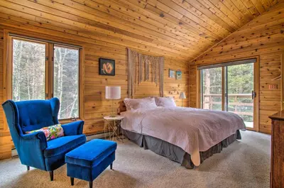 a bedroom with a bed and a blue chair at Tranquil Dumont Home with Creek and Mtn Views! in Dumont