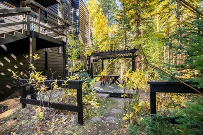 a garden with a bench next to a building at Tranquil Dumont Home with Creek and Mtn Views! in Dumont