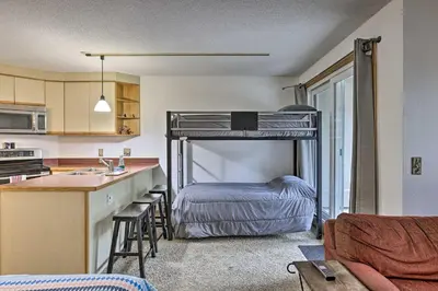 a bedroom with a bunk bed and a kitchen with a sink at Iron Horse Studio with Resort Amenities Walk to WP! in Winter Park