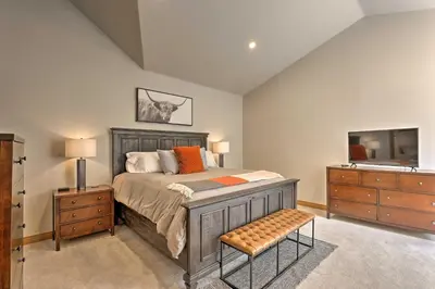 a bedroom with a bed and a dresser and a tv at Riverfront Silverthorne Condo Near Skiing! in Silverthorne