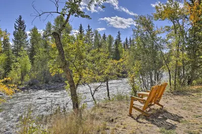 a wooden bench sitting next to a river at Riverfront Silverthorne Condo Near Skiing! in Silverthorne