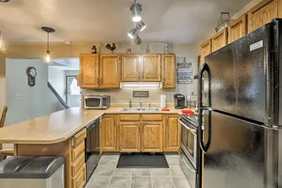a kitchen with wooden cabinets and a stainless steel refrigerator at 1 Block to Waterfront Grand Lake Condo with Balcony in Grand Lake