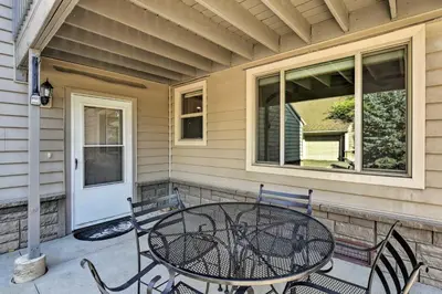 a patio with a table and chairs on a house at 1 Block to Waterfront Grand Lake Condo with Balcony in Grand Lake