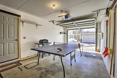 a ping pong table in a room with a garage at 1 Block to Waterfront Grand Lake Condo with Balcony in Grand Lake