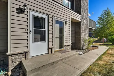 a house with a white door and a sidewalk at 1 Block to Waterfront Grand Lake Condo with Balcony in Grand Lake