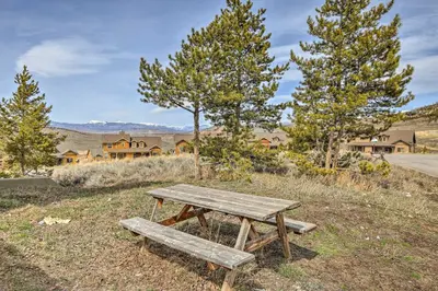 a wooden picnic table in a field with trees at Updated Studio Loft in Granby Epic Mountain Views in Granby