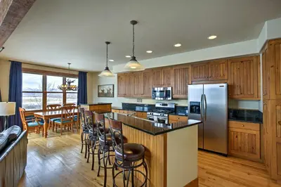 a kitchen with wooden cabinets and stainless steel appliances at 3 Mi to Granby Ranch Family-Friendly Home in Granby