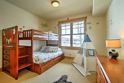 a bedroom with a bunk bed and a play crib at 3 Mi to Granby Ranch Family-Friendly Home in Granby