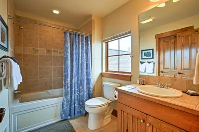 a bathroom with a toilet and a tub and a sink at 3 Mi to Granby Ranch Family-Friendly Home in Granby
