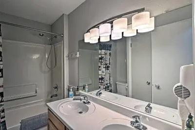 a bathroom with a sink and a large mirror at 2 Mi to Granby Ranch Condo with Hot Tub Access in Granby