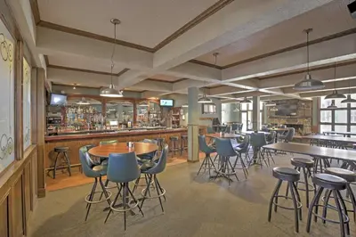 a restaurant with tables and chairs and a bar at 2 Mi to Granby Ranch Condo with Hot Tub Access in Granby