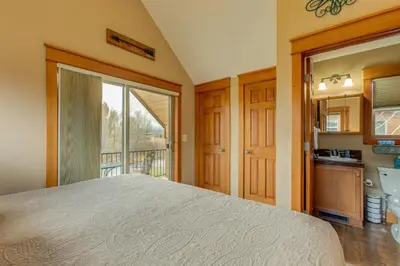 a bedroom with a large bed and a kitchen at Riverfront Cabin, 4 Mi to Granby Ranch in Granby