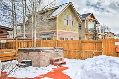 a house with a wooden fence and a hot tub at Riverfront Cabin, 4 Mi to Granby Ranch in Granby