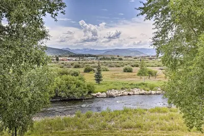 a river in the middle of a field with trees at Riverfront Cabin, 4 Mi to Granby Ranch in Granby