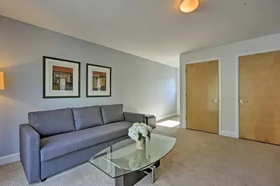a living room with a blue couch and a glass table at LoHi Apartment with Patio 1 Mi to Downtown Denver! in Denver