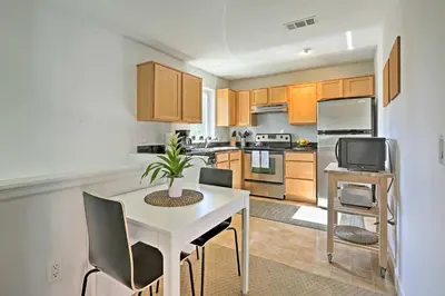 a kitchen with a white table and chairs and a tv at LoHi Apartment with Patio 1 Mi to Downtown Denver! in Denver