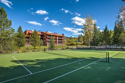 a tennis court in front of a building at Walk to Main St Frisco Condo with Community Pool! in Frisco