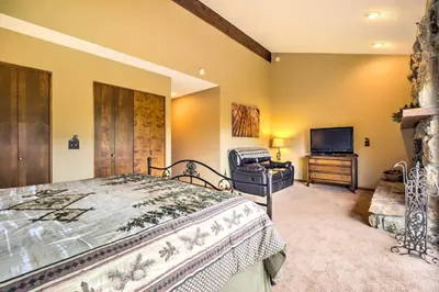 a bedroom with a bed and a flat screen tv at Estes Condo 3 Mi to Rocky Mountain National Park in Estes Park