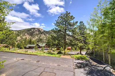 an empty street with trees and mountains in the background at Estes Condo 3 Mi to Rocky Mountain National Park in Estes Park