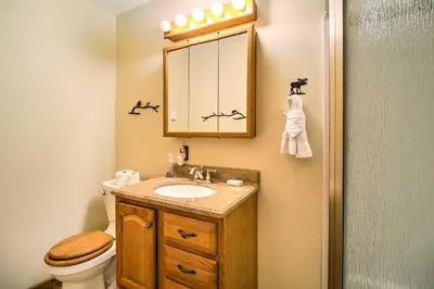 a bathroom with a sink and a toilet and a mirror at Estes Condo 3 Mi to Rocky Mountain National Park in Estes Park