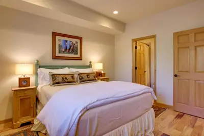 a bedroom with a large bed with white sheets at Lake and Mountain Views Stunning Estes Park Home! in Estes Park