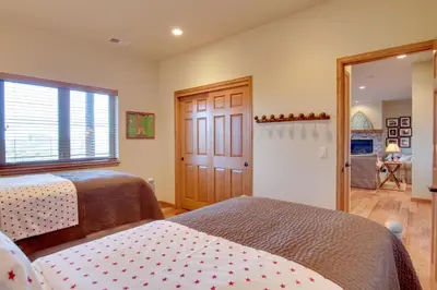 a bedroom with two beds and a sliding door at Lake and Mountain Views Stunning Estes Park Home! in Estes Park
