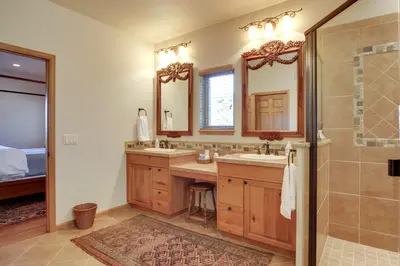 a bathroom with two sinks and a shower at Lake and Mountain Views Stunning Estes Park Home! in Estes Park