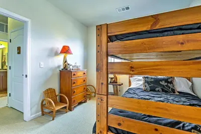 a bedroom with a wooden bunk bed and a chair at 18 Mi to Winter Park Granby Condo with Covered Deck in Granby