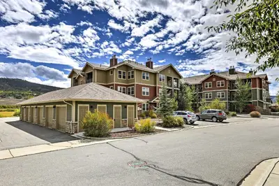 a large apartment building with cars parked in a parking lot at 18 Mi to Winter Park Granby Condo with Covered Deck in Granby