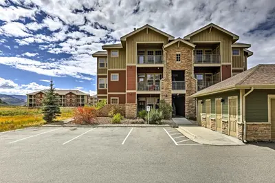 a large apartment building with a parking lot at 18 Mi to Winter Park Granby Condo with Covered Deck in Granby