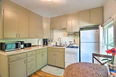 a kitchen with white cabinets and a white refrigerator at Historic Apartment - Walk to CSU Campus and Old Town in Fort Collins
