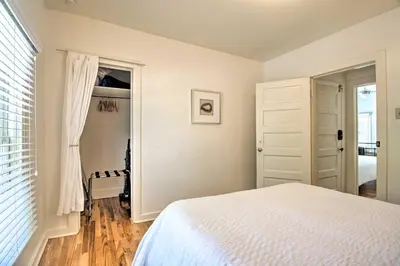 a white bedroom with a bed and a window at Historic Apartment - Walk to CSU Campus and Old Town in Fort Collins