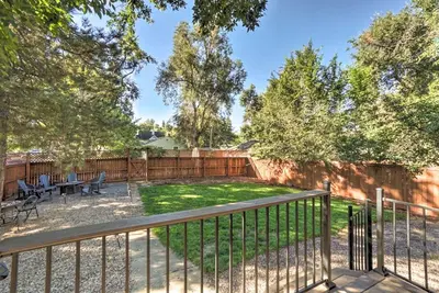 a backyard with a fence and a table and chairs at Historic Apartment - Walk to CSU Campus and Old Town in Fort Collins