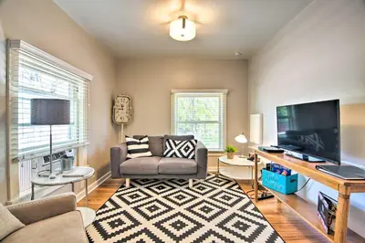 a living room with a couch and a flat screen tv at Historic Apartment - Walk to CSU Campus and Old Town in Fort Collins