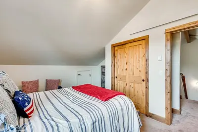 a bedroom with a bed and a wooden door at Newly Built Estes Park Townhome, 2 Miles to RMNP! in Estes Park