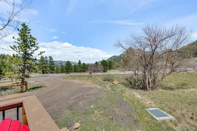 an empty road with a fence and trees on the side at Newly Built Estes Park Townhome, 2 Miles to RMNP! in Estes Park