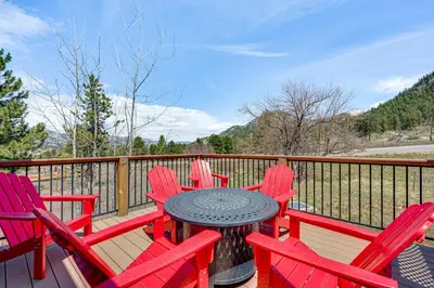 a patio with red chairs and a table on a deck at Newly Built Estes Park Townhome, 2 Miles to RMNP! in Estes Park