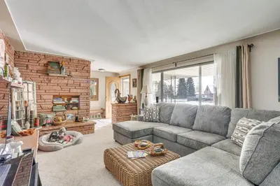 a living room with a gray couch and a brick wall at Private Lake Family Home with Large Yard in Denver! in Denver