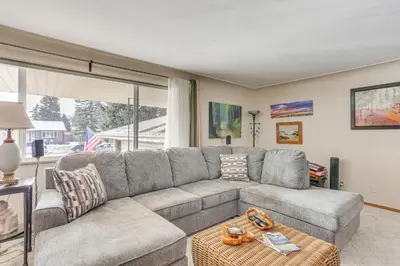 a living room with a gray couch and a large window at Private Lake Family Home with Large Yard in Denver! in Denver