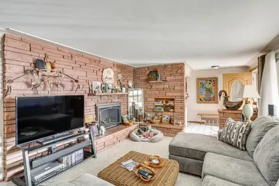 a living room with a brick wall at Private Lake Family Home with Large Yard in Denver! in Denver