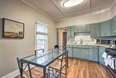 a kitchen with green cabinets and a glass table at Historic Redstone with Large Backyard, Walk To CSU! in Fort Collins