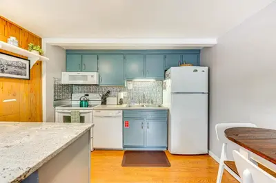 a kitchen with blue cabinets and a white refrigerator at Estes Park Condo with Deck and Views about 3 Miles to RMNP in Estes Park