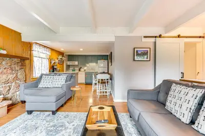 a living room with a couch and a table at Estes Park Condo with Deck and Views about 3 Miles to RMNP in Estes Park