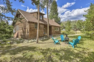 a log cabin with blue chairs in front of it at Walk to Grand Lake Historic Dtwn Cabin! in Grand Lake