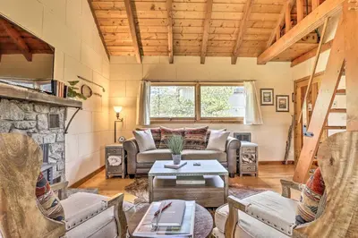 a living room with a couch and a table at Walk to Grand Lake Historic Dtwn Cabin! in Grand Lake